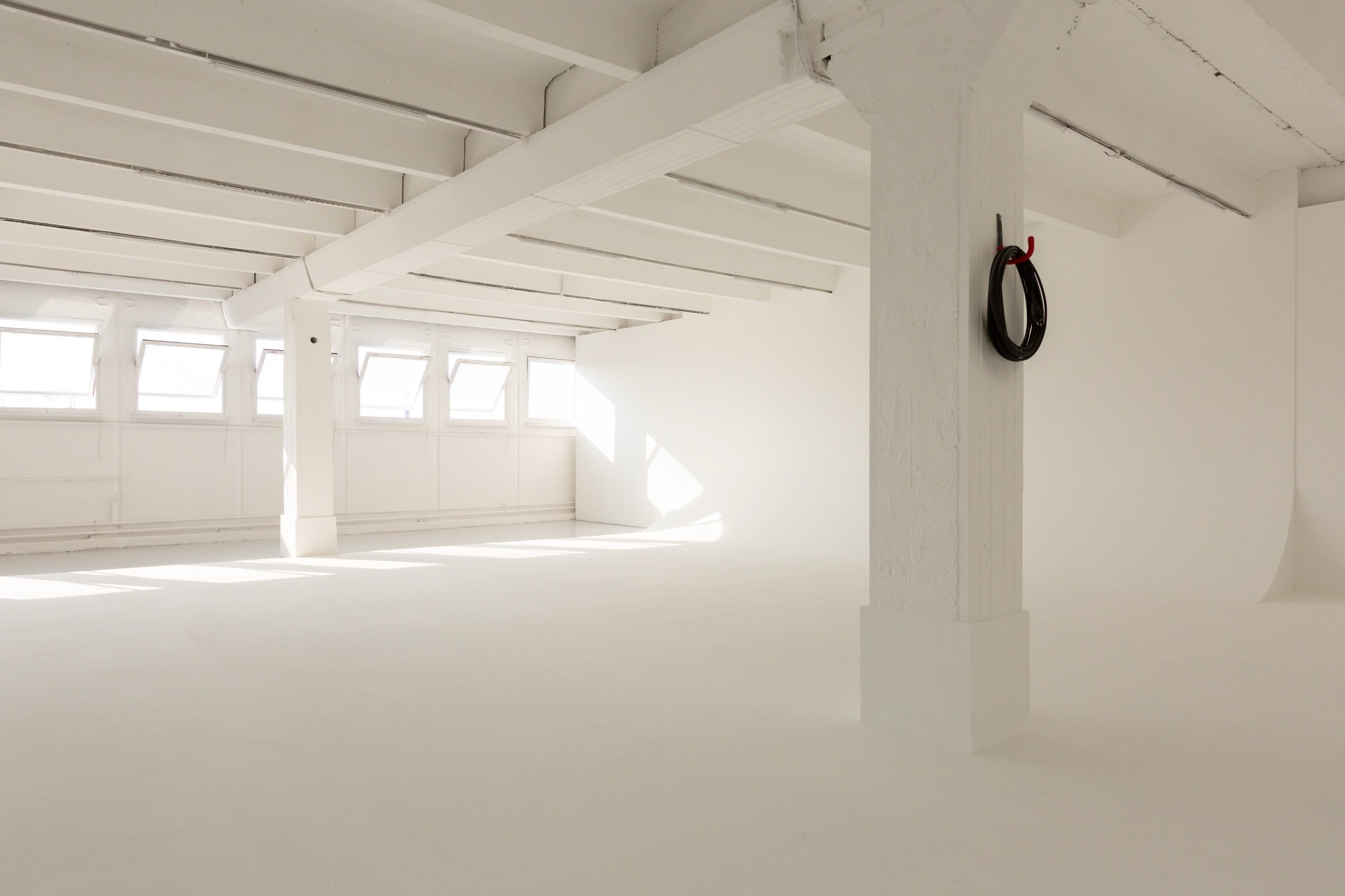 Picturepool Studios interior — coiled black cable hanging on a white pillar, with windows and infinity cove in the studio